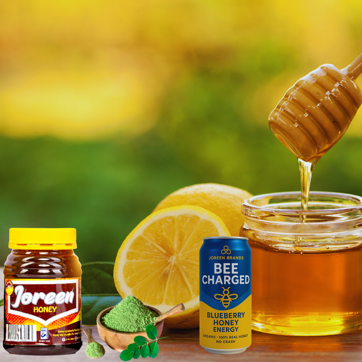 Joreen Brands Jars of honey, a can of blueberry honey charged energy, and lemons with a honey dipper on a blurred natural background.